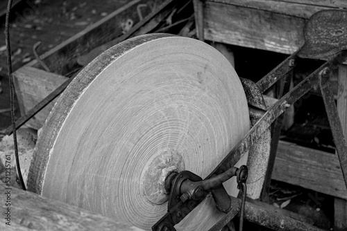 Closeup grayscale shot of antique grindstone for sharpening knives photo