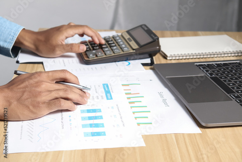 Businessman using calculators and laptops to calculate financial figures working in the office. Financial accounting concept