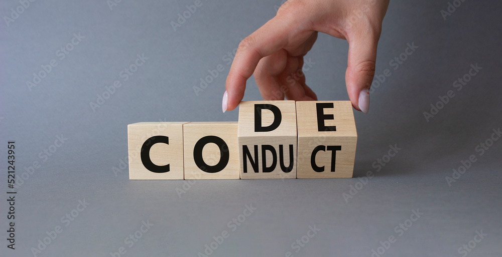 Code of conduct symbol. Businessman hand Turnes cubes and changes word Conduct to Code. Beautiful grey background. Business and Code of conduct concept. Copy space Code of conduct symbol. Businessman hand Turnes cubes and changes word Conduct to Code. Beautiful grey background. Business and Code of conduct concept. Copy space