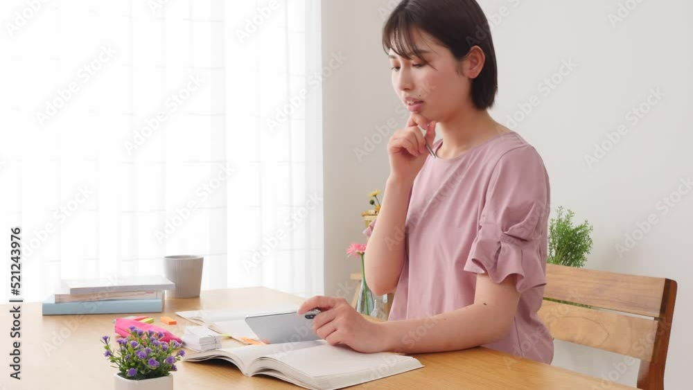 自宅でスマホで学習アプリを使って勉強する女性