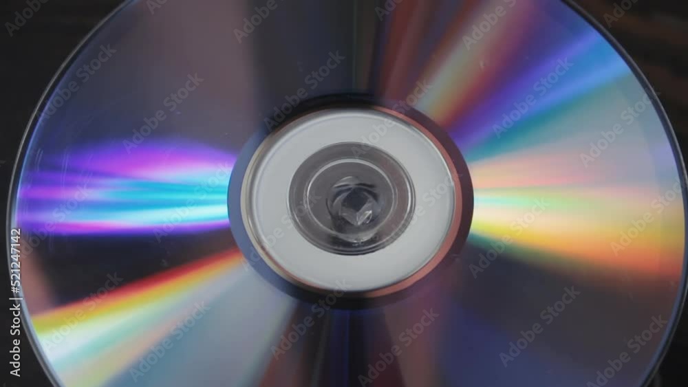 Scratched many times used cd spinning slowly, close up compact disc