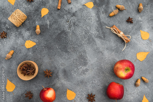 Thanksgiving day concept. Frame of fall leaves, apple, cinnamon and acorns on dark. Flat lay