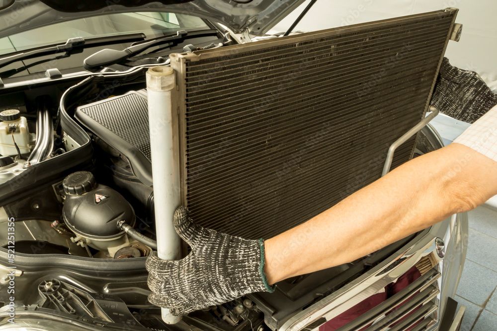Auto mechanic remove air conditioning condenser to maintenance, Car maintenance service.