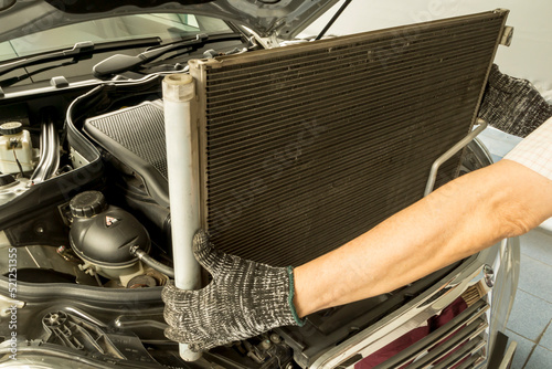 Auto mechanic remove air conditioning condenser to maintenance, Car maintenance service.