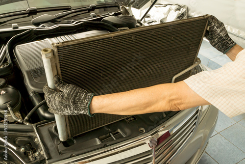 Auto mechanic remove air conditioning condenser to maintenance, Car maintenance service.
