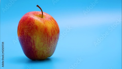 Red apple approaching from background to foreground on blue background	