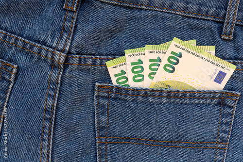 Euro bills are in the back pocket of jeans.