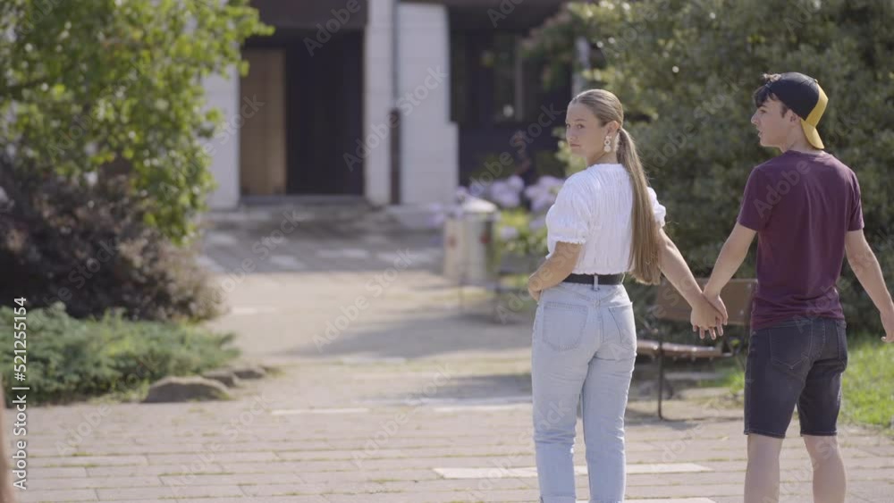 Teenager girl walking holding hands with boyfriend and looking to other guy, then boy getting jealous. Cheating and infidelity concept. Teenager girl walking holding hands with boyfriend and looking to other guy, then boy getting jealous. Cheating and infidelity concept.