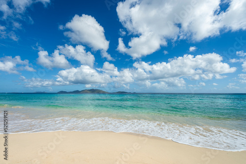 Jost Van Dyke viewed across turquoise Caribbean waters from the white sands of Apple Bay Beach on Tortola, BVI  photo