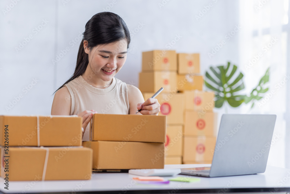 SME entrepreneur Business Young Asian freelance girl works with a laptop and box at home, about eCommerce, business, seller, Asian, employee, entrepreneur, box, merchant, Online SME business ideas, SME entrepreneur Business Young Asian freelance girl works with a laptop and box at home, about eCommerce, business, seller, Asian, employee, entrepreneur, box, merchant, Online SME business ideas,