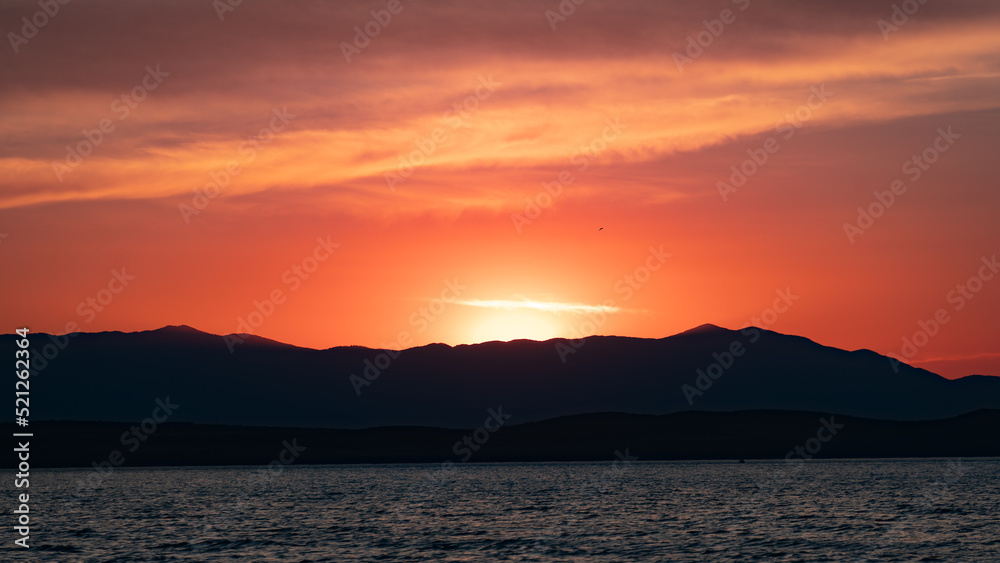 Colorful sunset over a coastal mountain range..