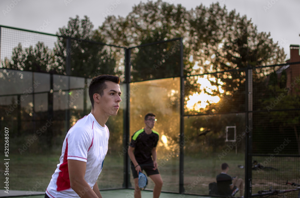 Título: young sportsman playing paddle tennis in an outdoor court.