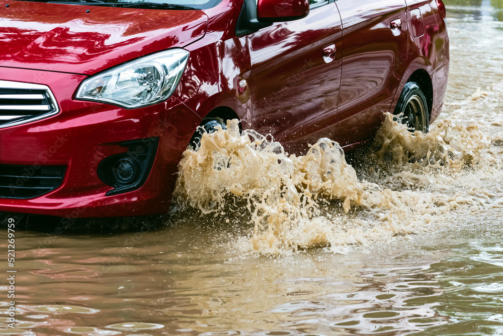 Car passing through a flooded road. Driving car on flooded road during