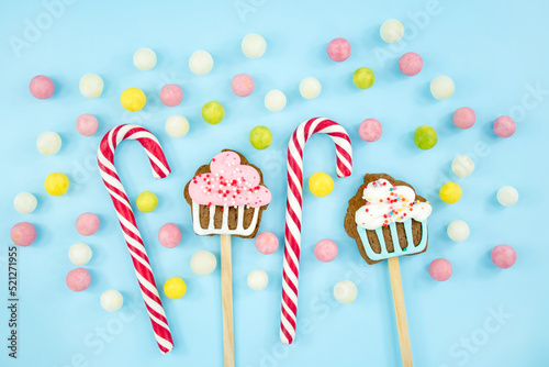 sweets, candies, cookies and lollipops on a blue background. Sweet Christmas Canes Top view copy space