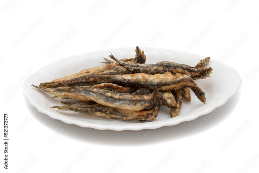 A white plate with fried anchovies, isolated on white background. Spanish food concept. A white plate with fried anchovies, isolated on white background. Spanish food concept.