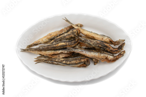 A white plate with fried anchovies, isolated on white background. Spanish food concept.