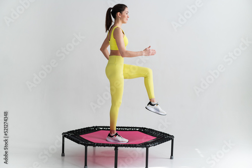 young fitness woman In sportswear jumping on sport trampoline