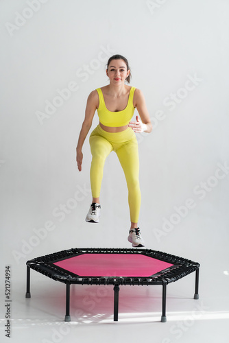 young fitness woman In sportswear jumping on sport trampoline