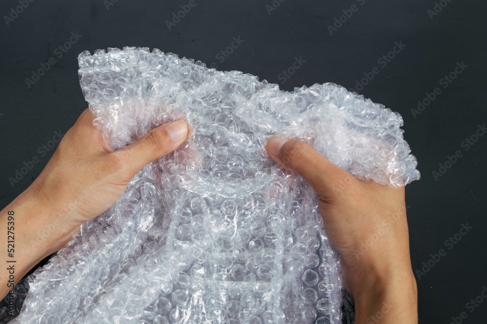 Girl bursts air bubbles on the package, Relieve daily stress with bubble wrap.
