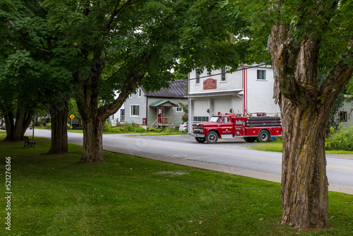 old fire truck in front of a wooden fire station in a village in the Eastern Townships, Quebec, Canada
