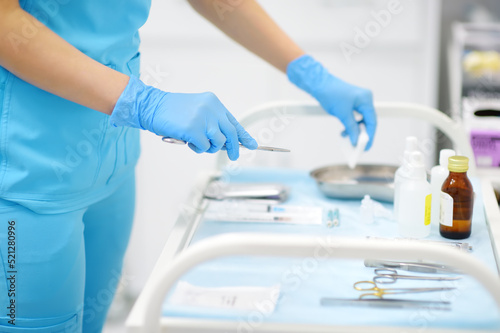 Nurse laying out medical instruments on the table in the operating room
