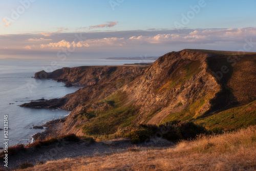 Sunset over the cliff on Cornwall coast. Beautiful evening landscape scenery.