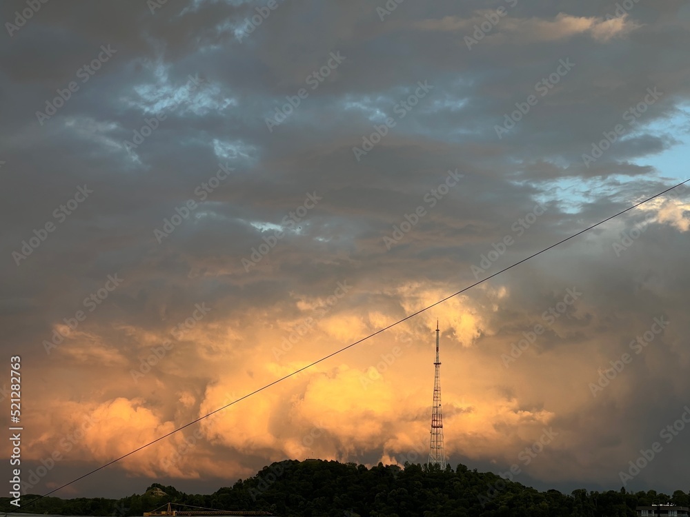 TV tower with wires against the background of the sky with sunset