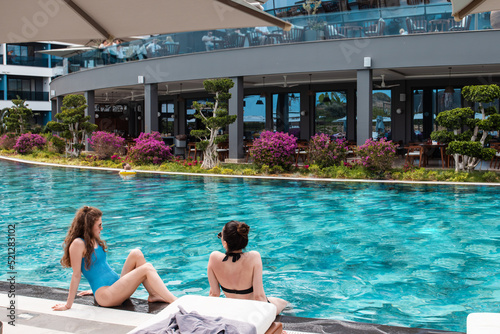 Antalia , Turkey 06 27 22 Summer holidays concept. Slim young women in bikini on the sun lounger near swimming pool in hotel resort photo