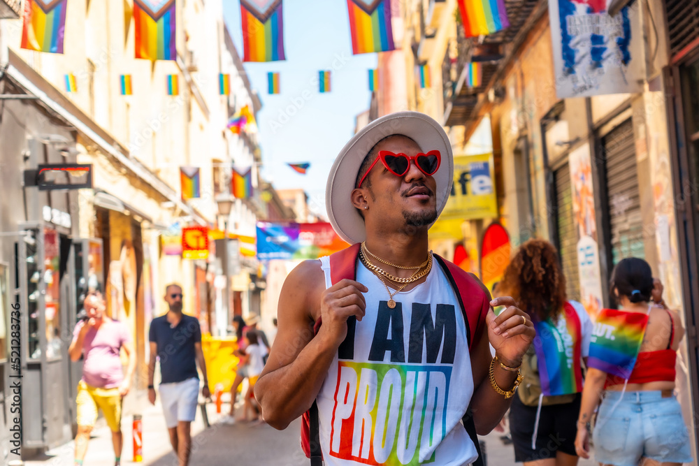 A gay black ethnicity man enjoying and smiling at the pride party, LGBT flag