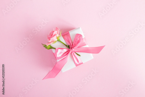 Gift box with pink rose on the pink  background.Top view. Copy space. © Liudmyla