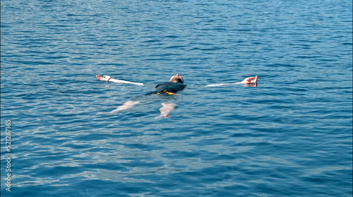 The young guy drowned in the sea. The body floats on the surface photo