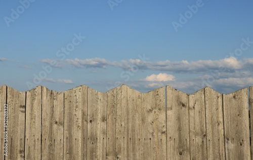 Close up wooden grey fence and blue sky