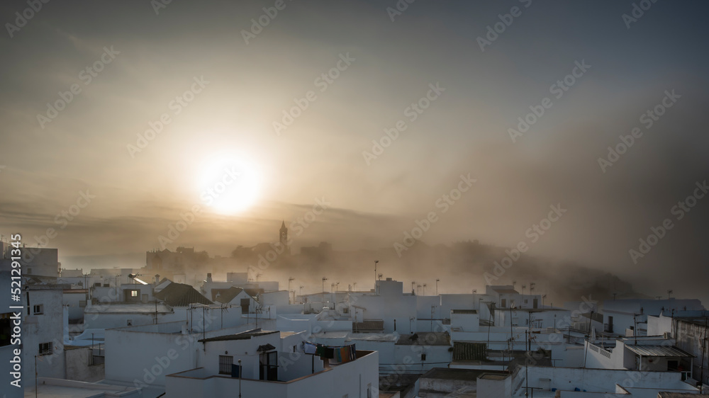 Fototapeta premium Spanish village on a foggy morning. Beautiful Andalusian Pueblo Blanco (white village) at sunrise. Vejer de la Frontera is one of the most beautiful Pueblos Blancos, Cádiz province, Andalusia, Spain.
