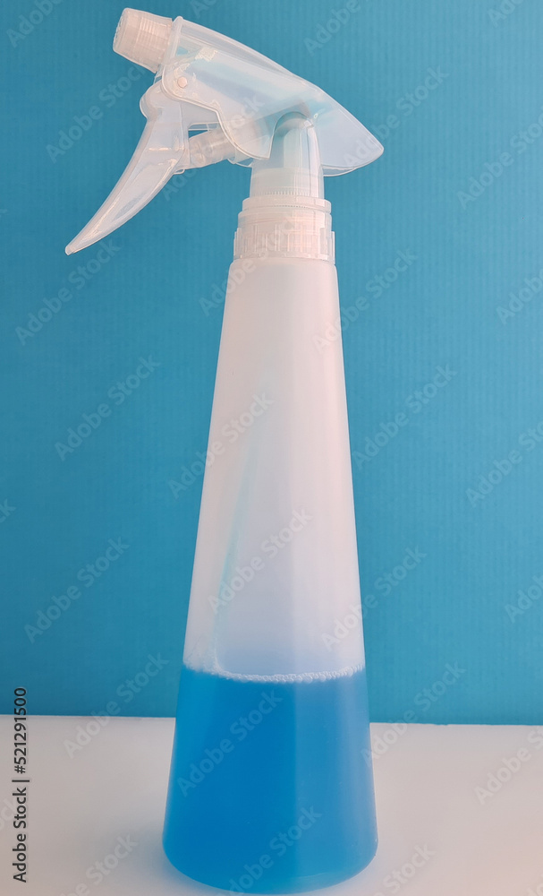 Spray bottle with blue disinfectant liquid closeup Spray bottle with blue disinfectant liquid closeup