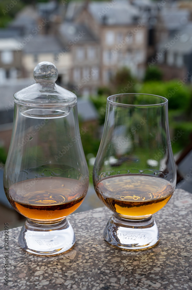 Two glasses of scotch whiskey with view on old houses on background, Edinburgh whisky tasting tour, Scotland Two glasses of scotch whiskey with view on old houses on background, Edinburgh whisky tasting tour, Scotland