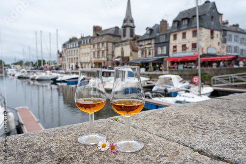 Photography Tasting of apple calvados drink in old Honfleur harbour with boats and old house