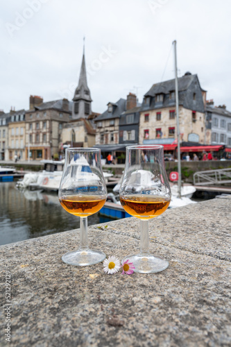 Tasting of apple calvados drink in old Honfleur harbour with boats and old houses on background, Normandy, France © barmalini