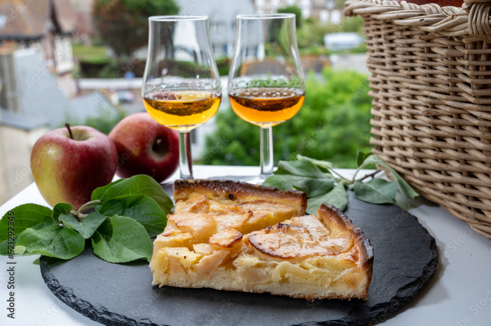 Tasting of baked apple cake and strong alcoholic drink calvados made from apples in Normandy, Calvados region, France - obrazy, fototapety, plakaty 