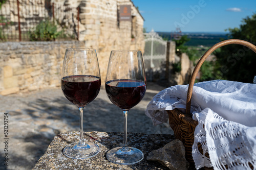 Glass of red dry wine and ruins of medieval castle of Châteauneuf-du-Pape ancient wine making village in France photo