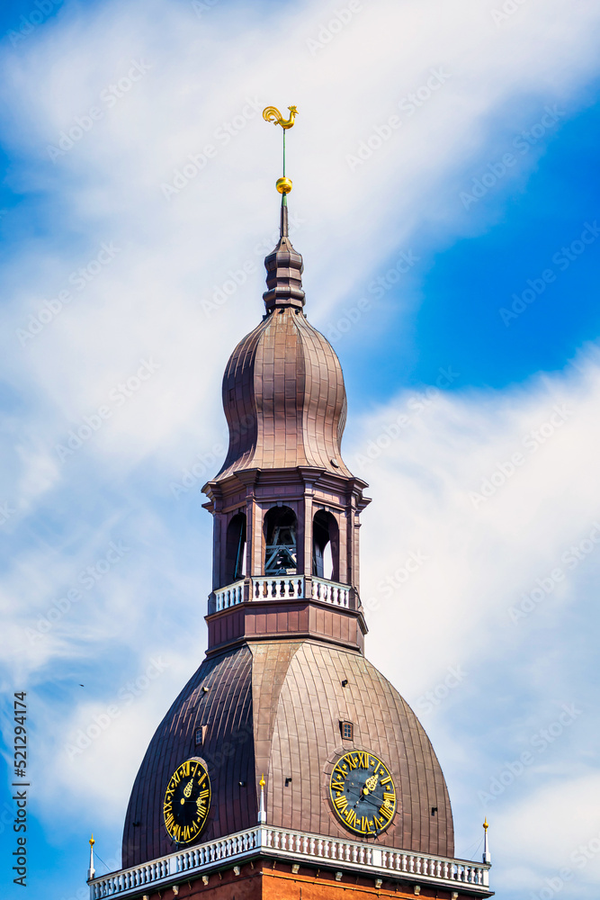 Symbol of old Riga town in Latvia - golden cockerel (rooster) topping bell tower of Riga Doms Cathedral.