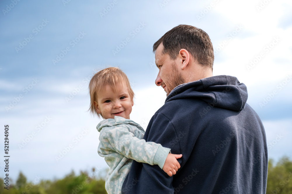 The father is holding a little girl in his arms. The concept of happy fatherhood. Father's Day. The father is holding a little girl in his arms. The concept of happy fatherhood. Father's Day.