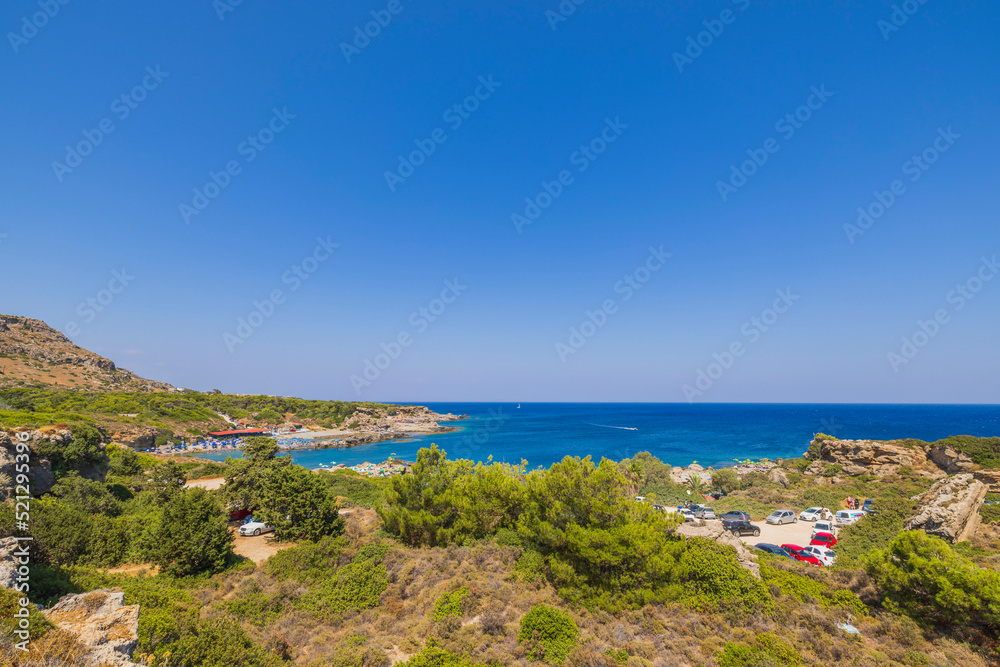 Beautiful panoramic landscape view of island on dark blue sea water merging with cloudless sky on background. Rhodes. Greece. 