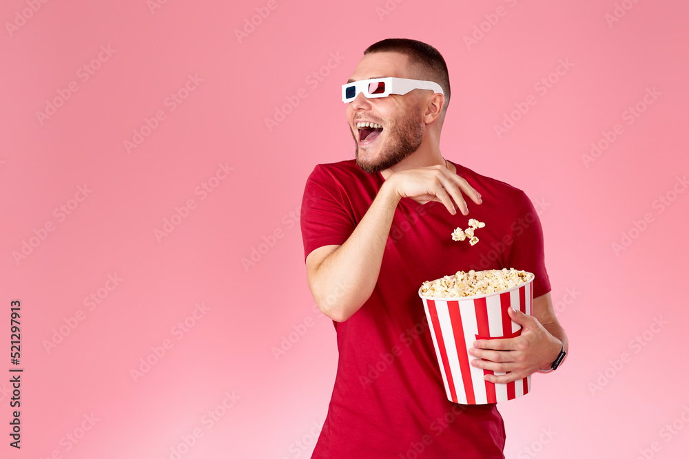 Young caucasian man in 3d glasses eating popcorn Young caucasian man in 3d glasses eating popcorn