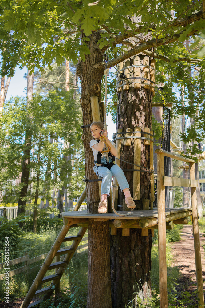 Rope park. Child girl having fun at adventure park. 