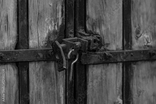 metal lock of a wooden gate in black and white © Daniel