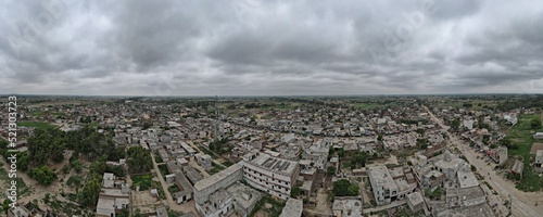 A 180-degree aerial panorama of an industrial factory in district Narowal of Punjab province and its surroundings in very cloudy weather. 