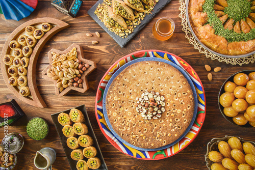 Arabic Cuisine: Middle Eastern desserts. Delicious collection of Ramadan traditional desserts. Served with tasty nuts, honey syrup and sugar syrup .Top view with close up. photo