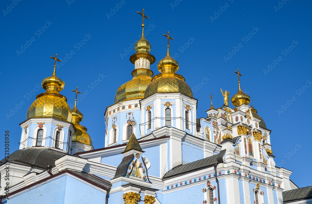 Shiny golden cupolas of the St. Michaels Golden Domed Monastery on blue sky background. Kyiv, Ukraine