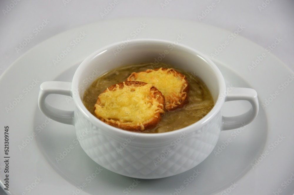 French onion soup with croutons covered cheese in white bowl French onion soup with croutons covered cheese in white bowl
