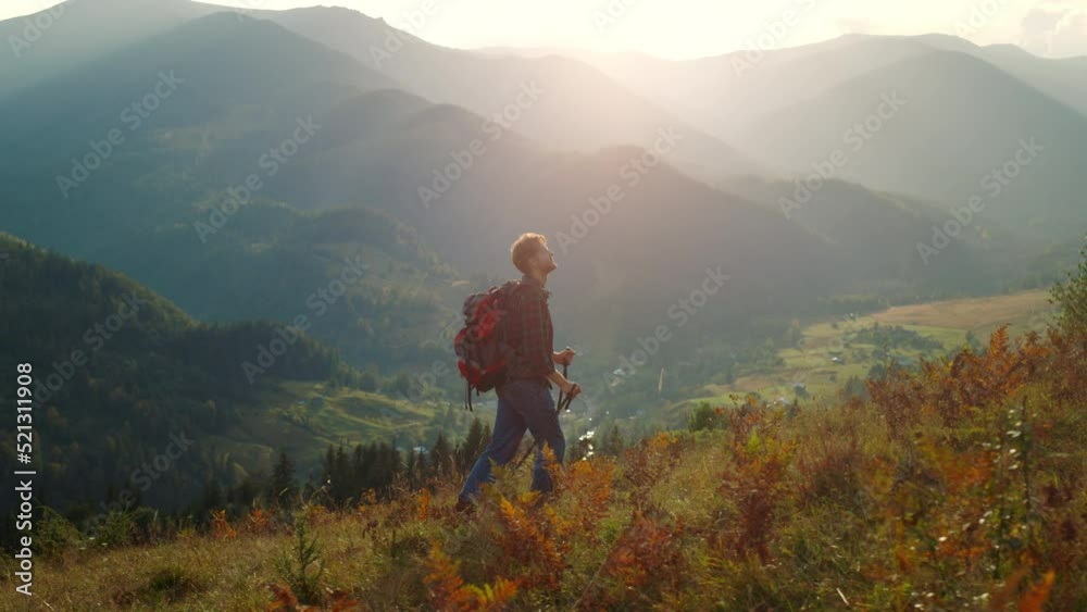 Active man walk mountains landscape. Sporty tourist hiking using trekking poles. Active man walk mountains landscape. Sporty tourist hiking using trekking poles.